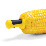 DREAMFARM yellow four-piece corn holder set with locking clips for easy handling of corn on the cob.