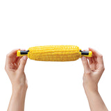 DREAMFARM yellow four-piece corn cob holder set with lock rings, designed for easy grilling and serving of corn on the cob.