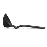 DREAMFARM red silicone ladle with a long handle for serving soups and stews in a modern kitchen setting.