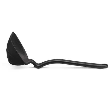 DREAMFARM red silicone ladle with a long handle for serving soups and stews in a modern kitchen setting.