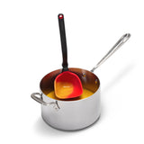 Red DREAMFARM Schöpfkelle (ladle) with a long handle, designed for serving soups and liquids in the kitchen.