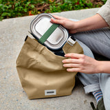 BLACK+BLUM lunchbag in clay color with a sleek design, 6.7-liter capacity, suitable for carrying lunch and snacks.