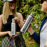 Black+Blum insulated bottles in two sizes, black and orange, designed for keeping drinks hot or cold during outdoor activities.