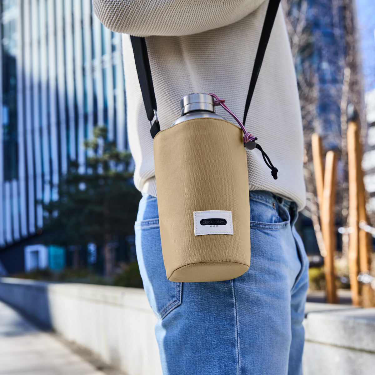 BLACK+BLUM bottle bag in clay with black strap, designed for carrying bottles outdoors or in the city.