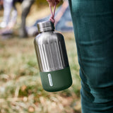 BLACK+BLUM Explorer insulated bottle in orange with olive paracord, 650ml, showcasing its durable design and portable lid.