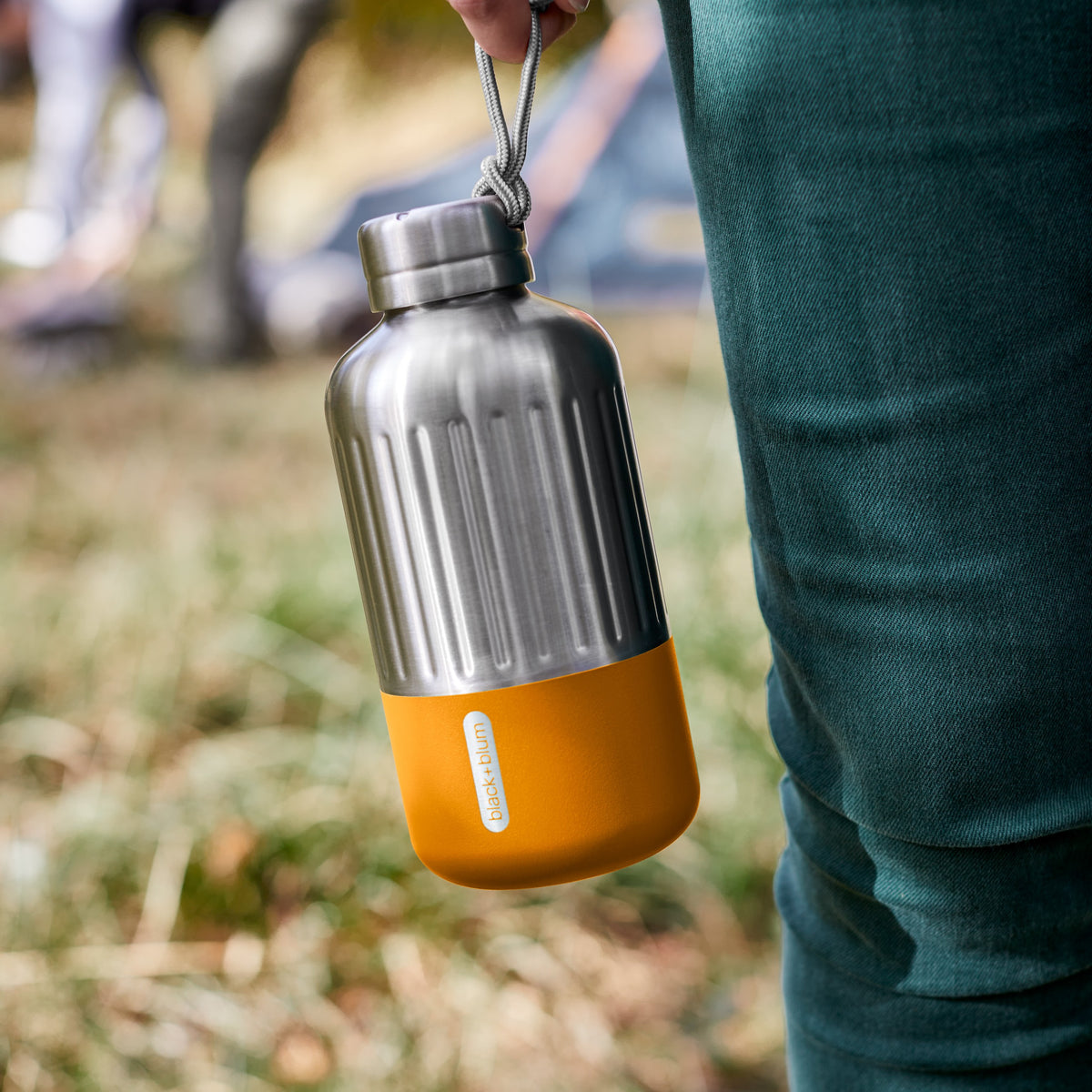 BLACK+BLUM Explorer insulated bottle in orange with paracord handle, 650ml, designed for hot and cold beverages.