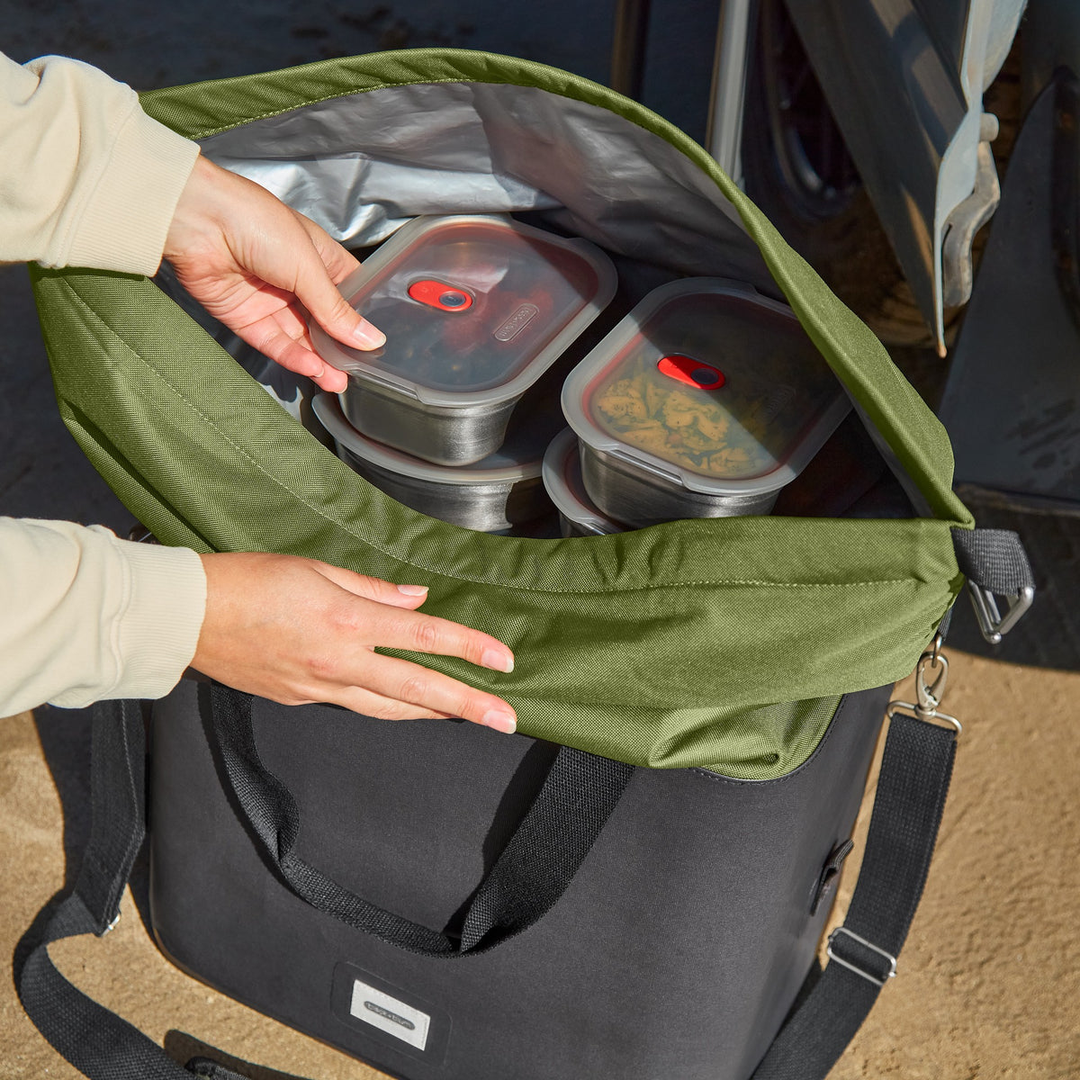 Black+Blum insulated cooler bag in moss color, foldable and open, designed for keeping food and drinks cool during outdoor activities.