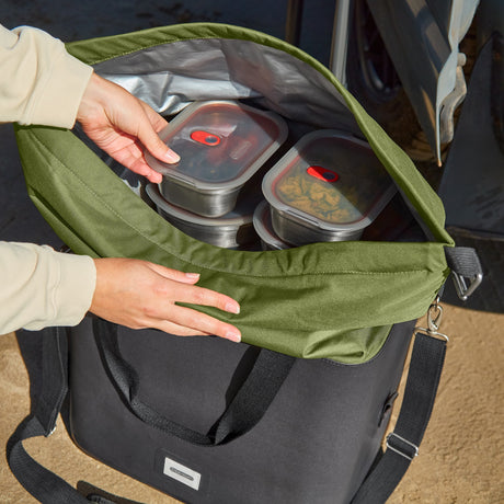 Black+Blum insulated cooler bag in moss color, foldable and open, designed for keeping food and drinks cool during outdoor activities.