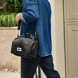 Black+Blum insulated lunchbag with shoulder strap, large black fabric, designed for carrying lunch in a stylish, practical way.