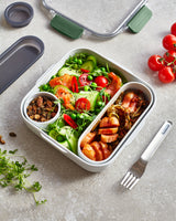 BLACK+BLUM Original lunchbox with salad and olives, showcasing its sleek black design and compartmentalized interior.