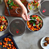 Black+Blum stainless steel multifunctional storage box with three small bowls and lid, shown in a flatlay with people.