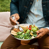 Set of four BLACK+BLUM stainless steel picnic plates with matching spork for outdoor dining and travel.
