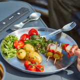 Set of four BLACK+BLUM stainless steel picnic plates with sporks, ideal for outdoor dining and eco-friendly tableware.