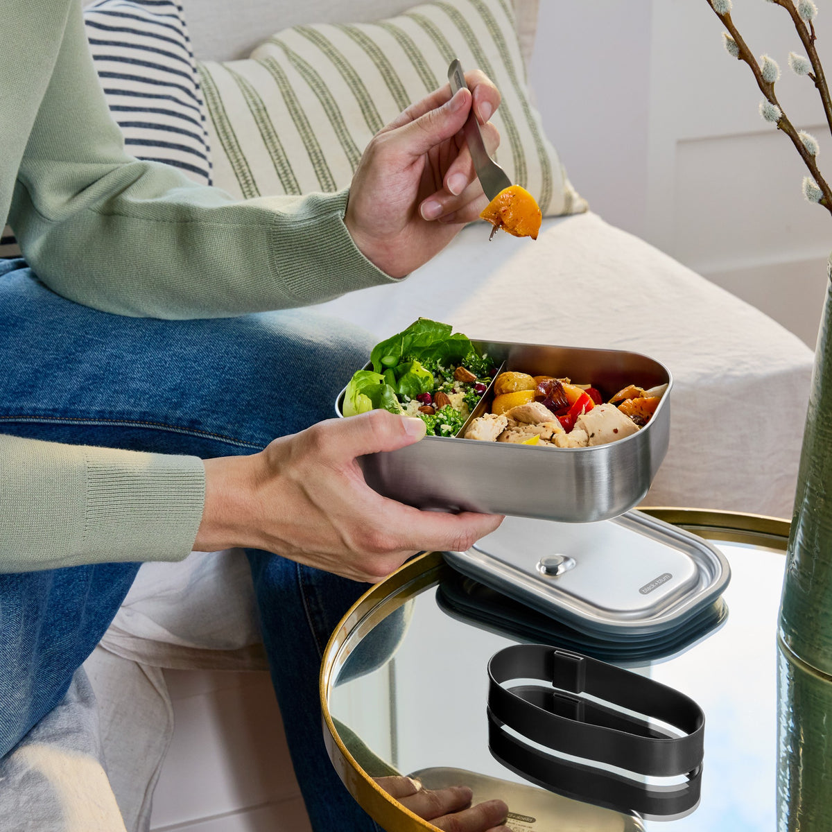 BLACK+BLUM Classic 1000ML steel lunchbox held in hand, showing sleek black design and compact size for meal storage.