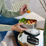 BLACK+BLUM Classic 1000ML steel lunchbox held in hand, showing sleek black design and compact size for meal storage.
