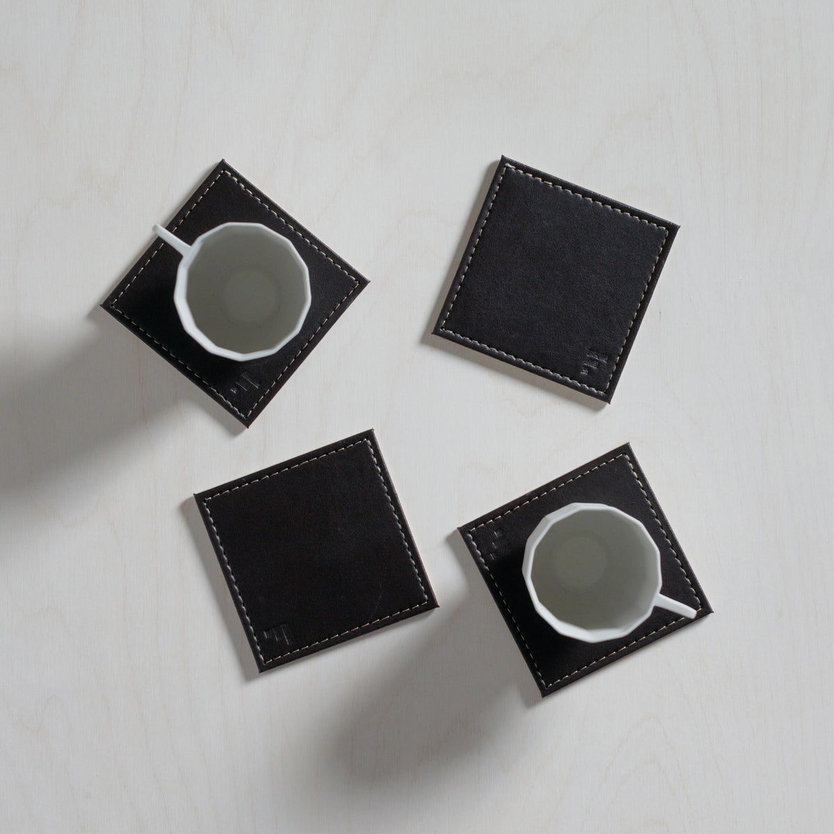 Set of four FREEFORM DUO coasters with modern geometric design, made of durable materials for protecting surfaces.
