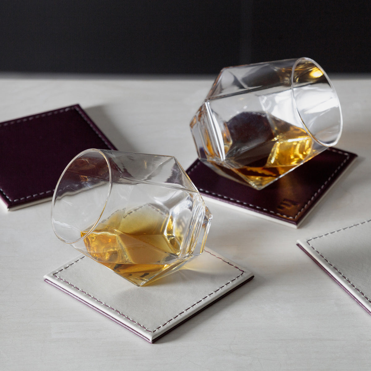 Set of four FREEFORM DUO coasters with modern design, made of durable material, suitable for protecting surfaces from drink spills.