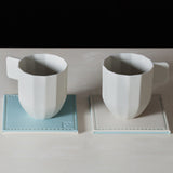 Set of four FREEFORM DUO coasters with stylish design, ideal for protecting surfaces from drink condensation.